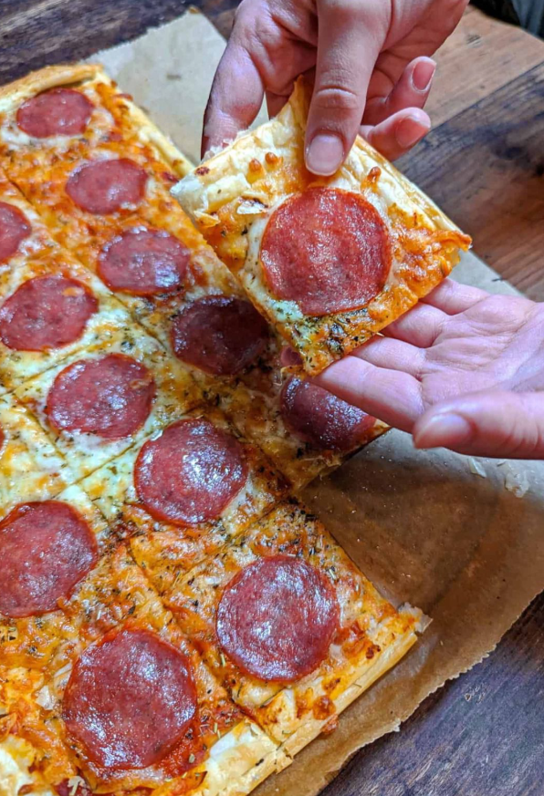 Ti è venuta voglia di una pizza davvero deliziosa? Allora dovresti assolutamente provare questa pizza croccante di pasta sfoglia con salame sostanzioso.